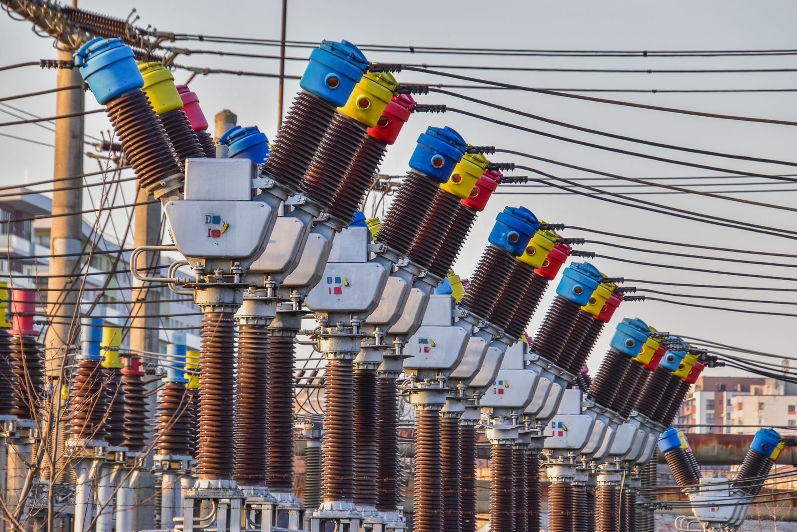 Rząd kolorowych aparatów wysokiego napięcia na stacji elektroenergetycznej